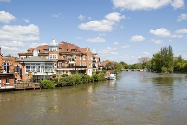 The River Thames flowing through the Berkshire countryside, surrounded by green banks and trees.