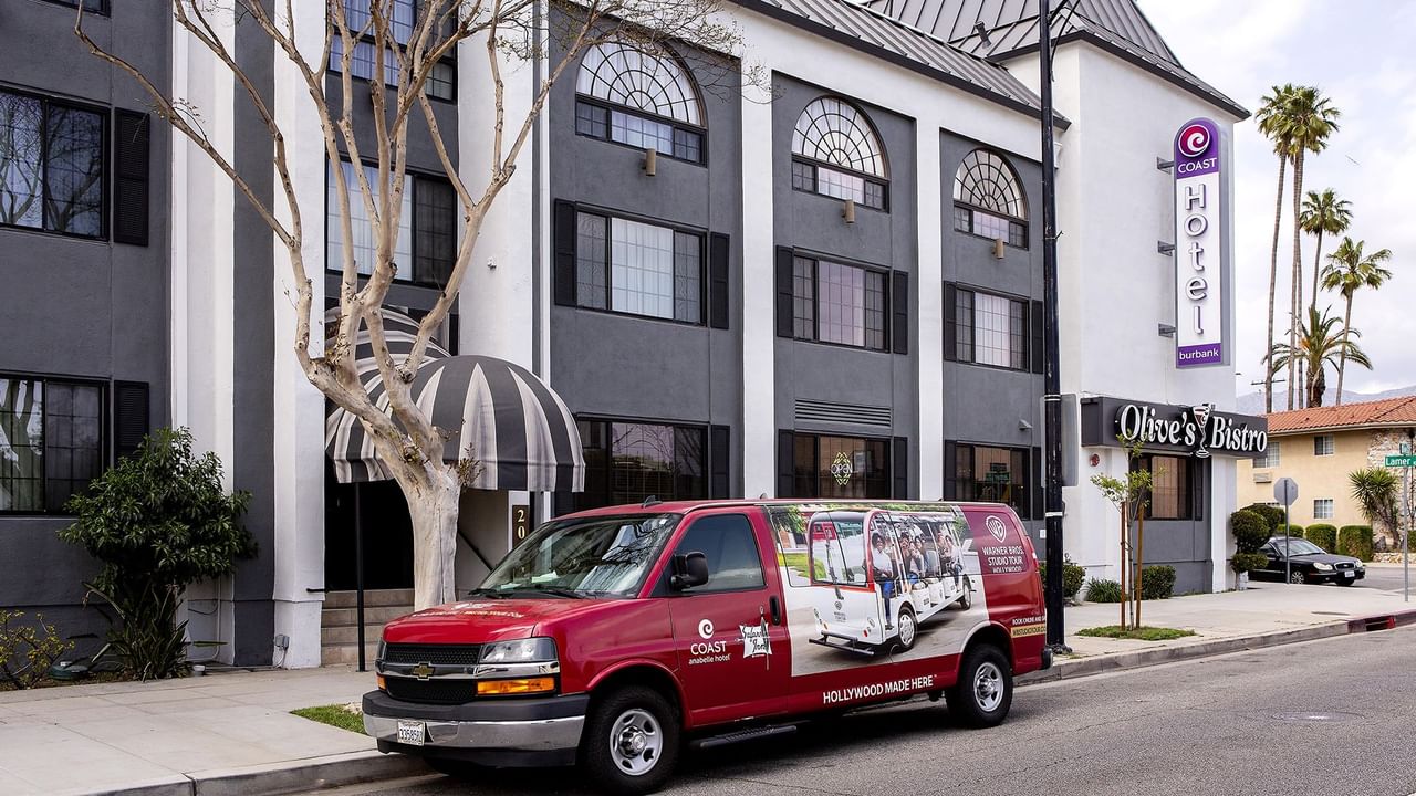A red van parked in front of Coast Burbank Hotel