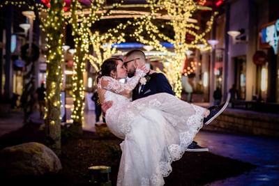 groom carrying bride as they kiss