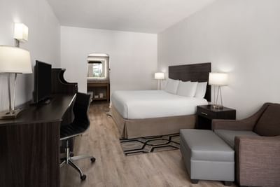 Deluxe King room with a queen bed, dark wood furniture, and a sleek work station at The Harrison Hotel Downtown Hollywood