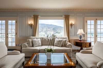 Living room area with a comfy sofa overlooking the mountains in Mt. Ada, Catalina Island Company