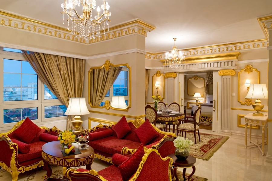 Royal Suite features Red sofas and a round table under a crystal chandelier at Warwick Doha Hotel