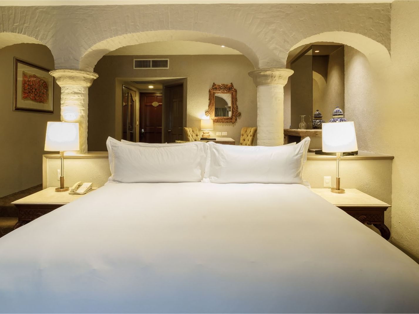 King Governor Suite framed by rustic stone arches and classic decor in a luxury suite at Quinta Real Guadalajara