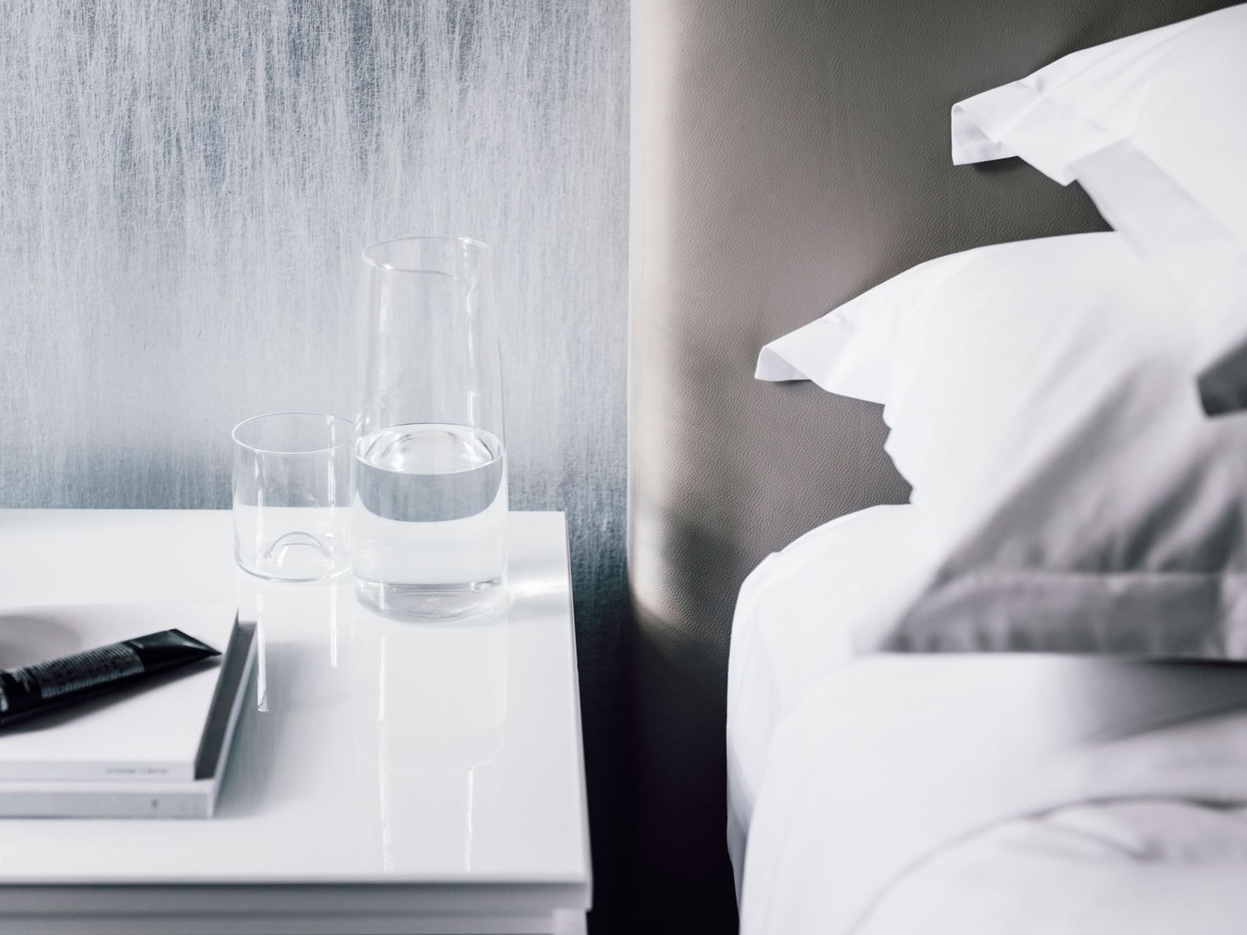 Glass of water by the bed in a Room at The Como Hotel Melbourne