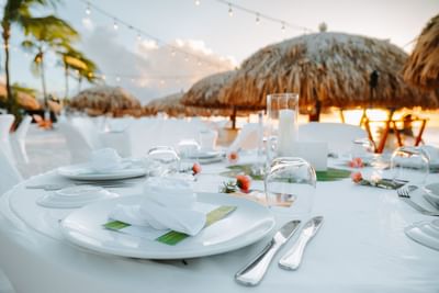 Lights & tables arranged outdoors by the shore at night in Passions on the Beach
