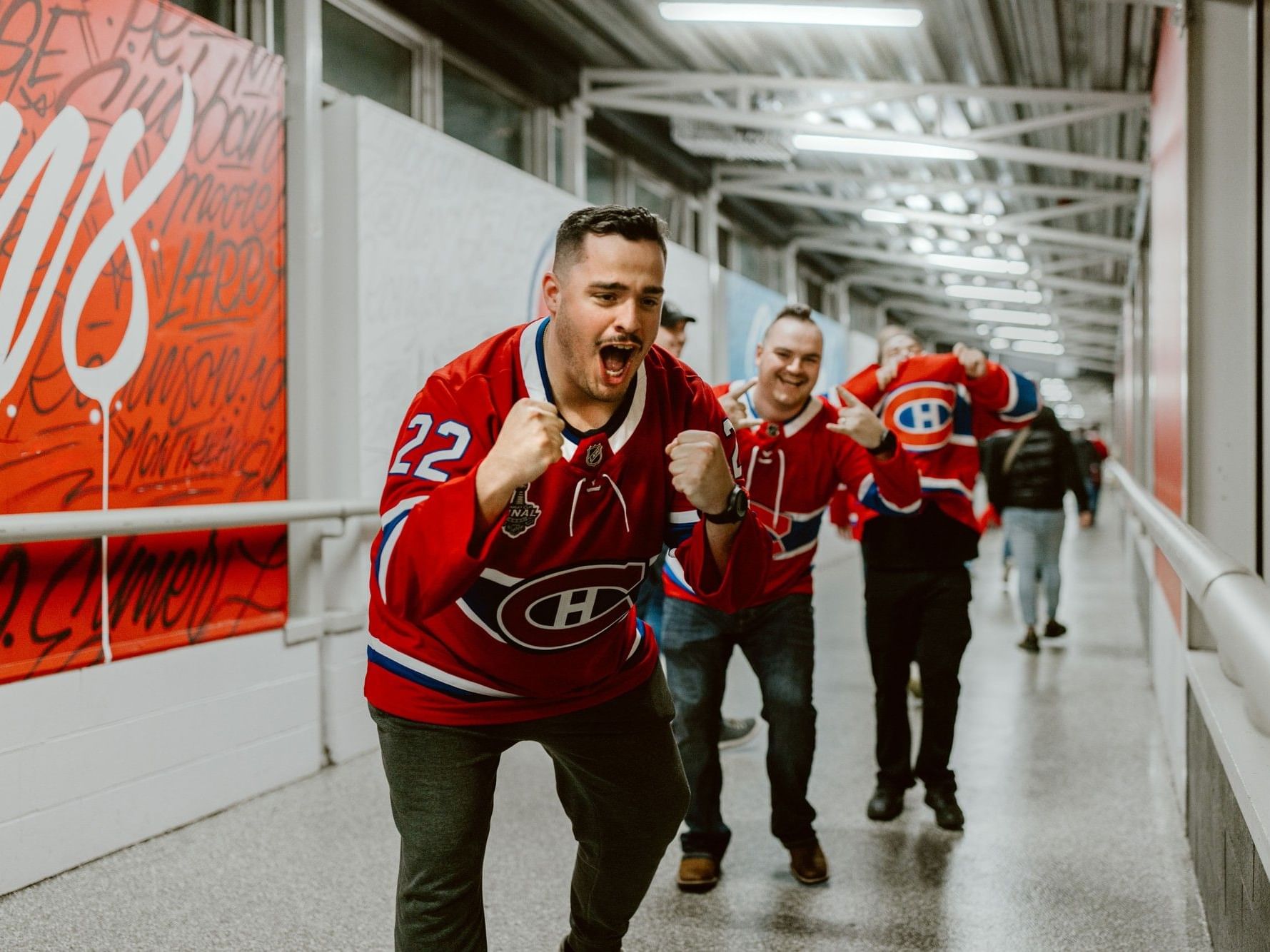 Groupe de fans de hockey en liesse dans un couloir au Centre Bell.
