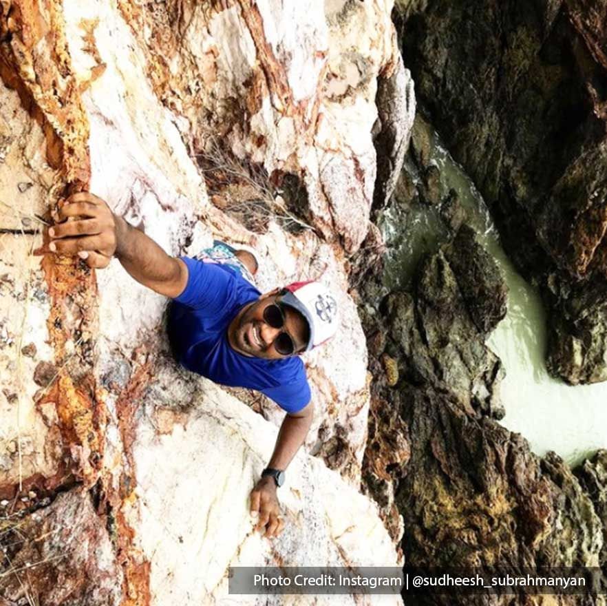 Man rock climbing on a cliff in Tanjung Tuan - Lexis Hibiscus