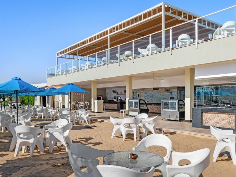 Beach Restaurant with white seating, blue umbrellas, and two-level dining area at Pickalbatros Dana Beach Resort Hurghada