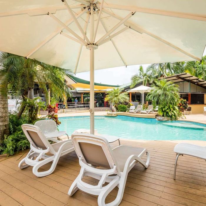 Sunbeds & umbrella by outdoor pool at Novotel Darwin Airport