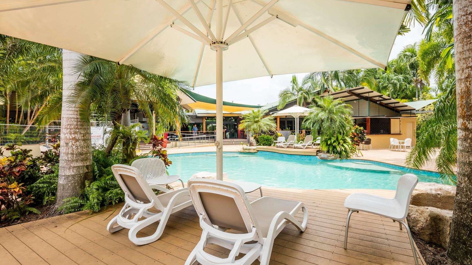 Sunbeds & umbrella in outdoor pool at Darwin Airport Hotels