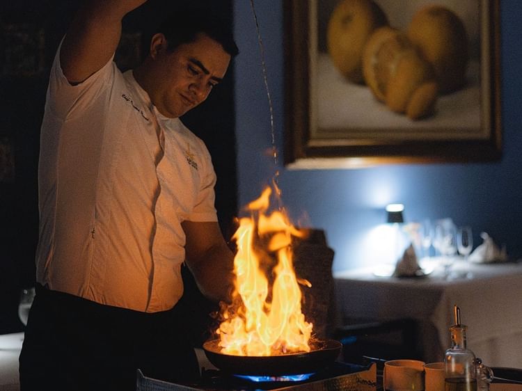 Chef skillfully prepares a flaming dish in Canto Del Mar at Marquis Los Cabos Resort