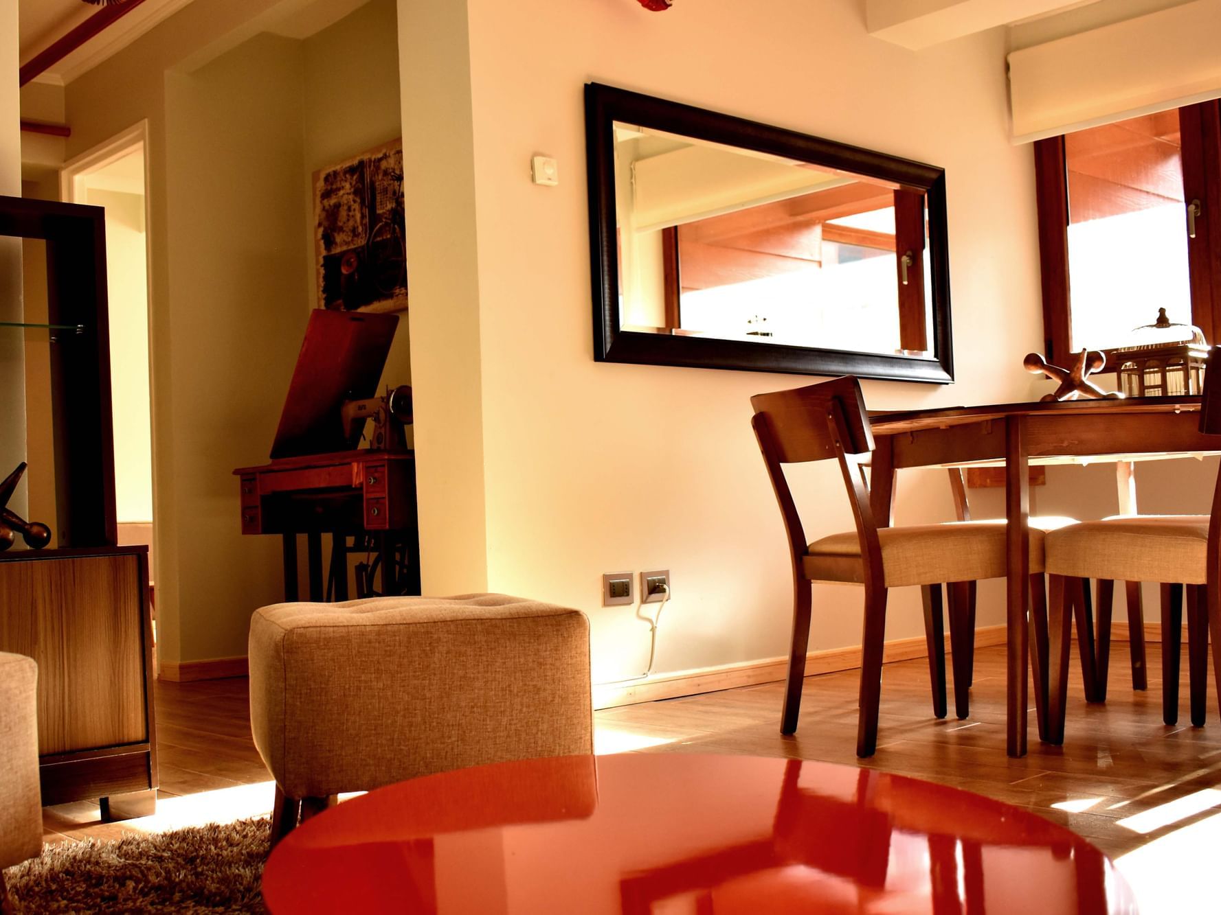 Sala de estar e jantar do NOI Junior Apartamento com móveis em madeira e luz natural no NOI Puma Lodge em Machalí.