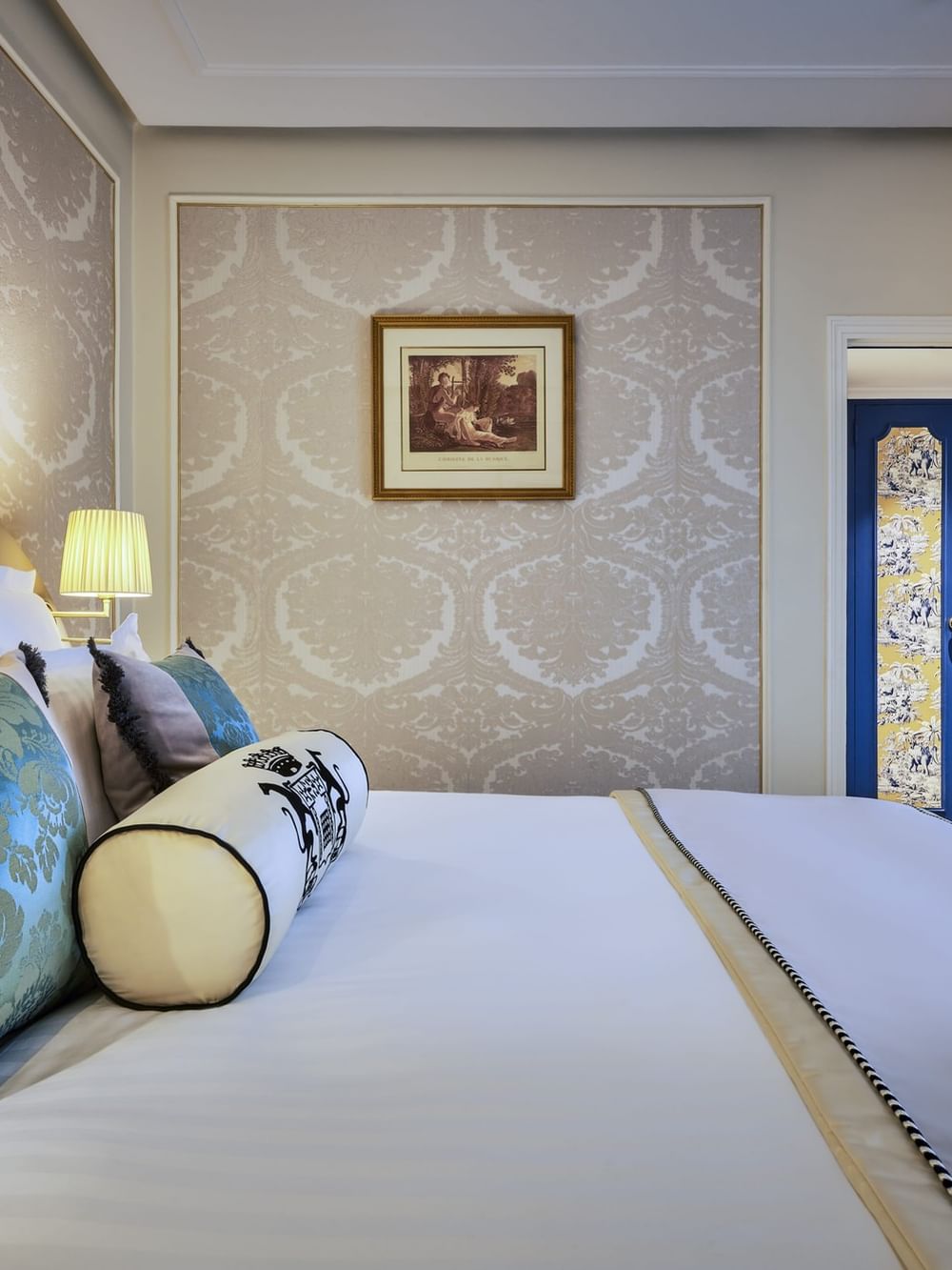 Élégante chambre Deluxe avec un grand lit, du papier peint à motifs et une vue sur Paris à l'Hôtel Westminster - Paris.