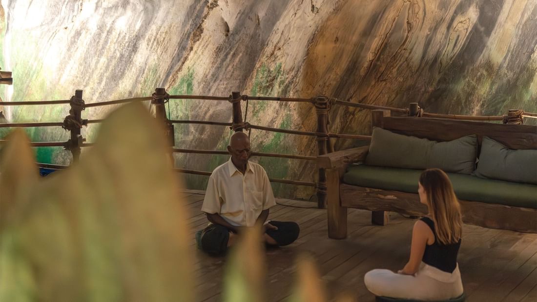 Man and a woman meditating in group wellness classes held at The Banjaran Hotsprings Retreat