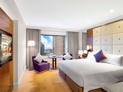 Bed & lounge chairs in Deluxe King Room at Amora Hotel Sydney