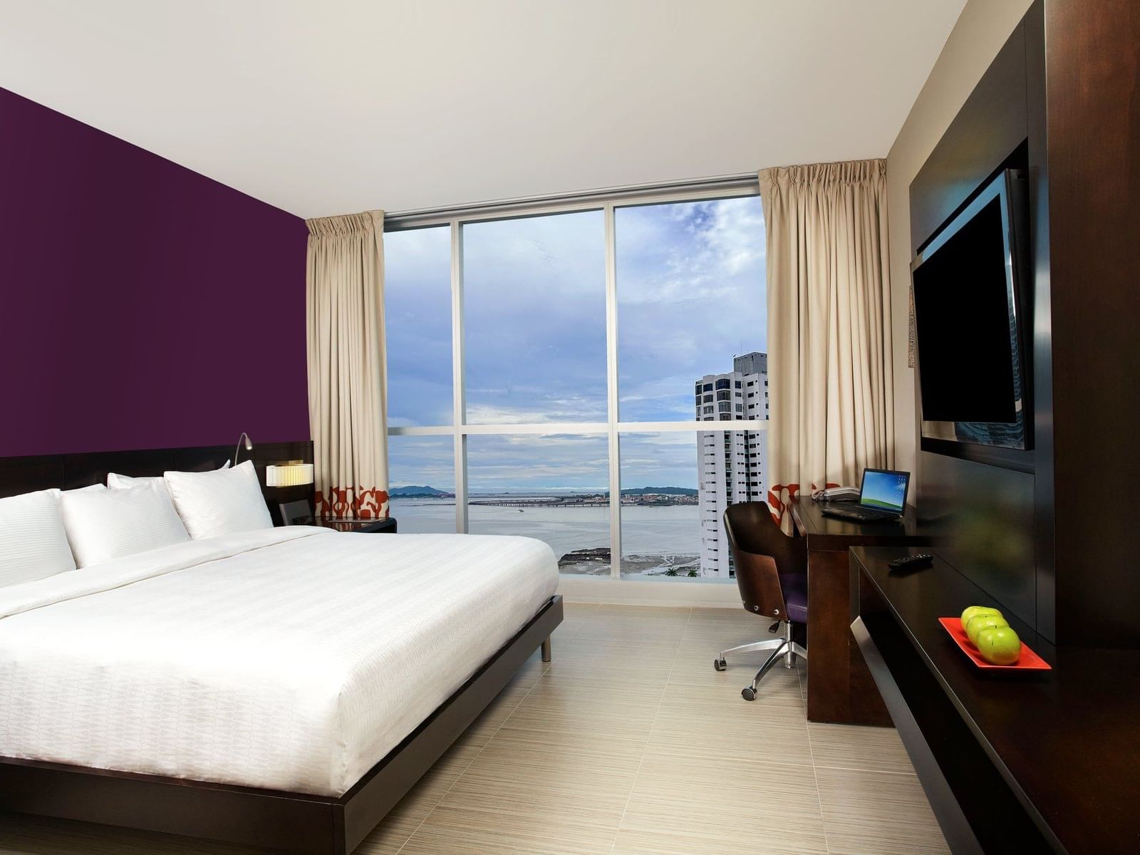 Bed with TV area in Studio Suite Ocean View at Megapolis Hotel Panama