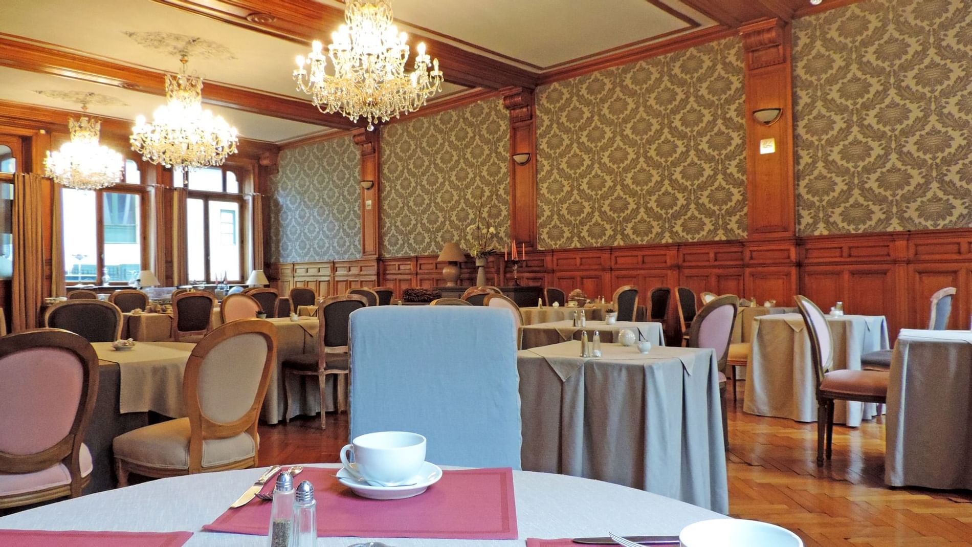 Arranged chairs & tables with tea cups at The Originals Hotels