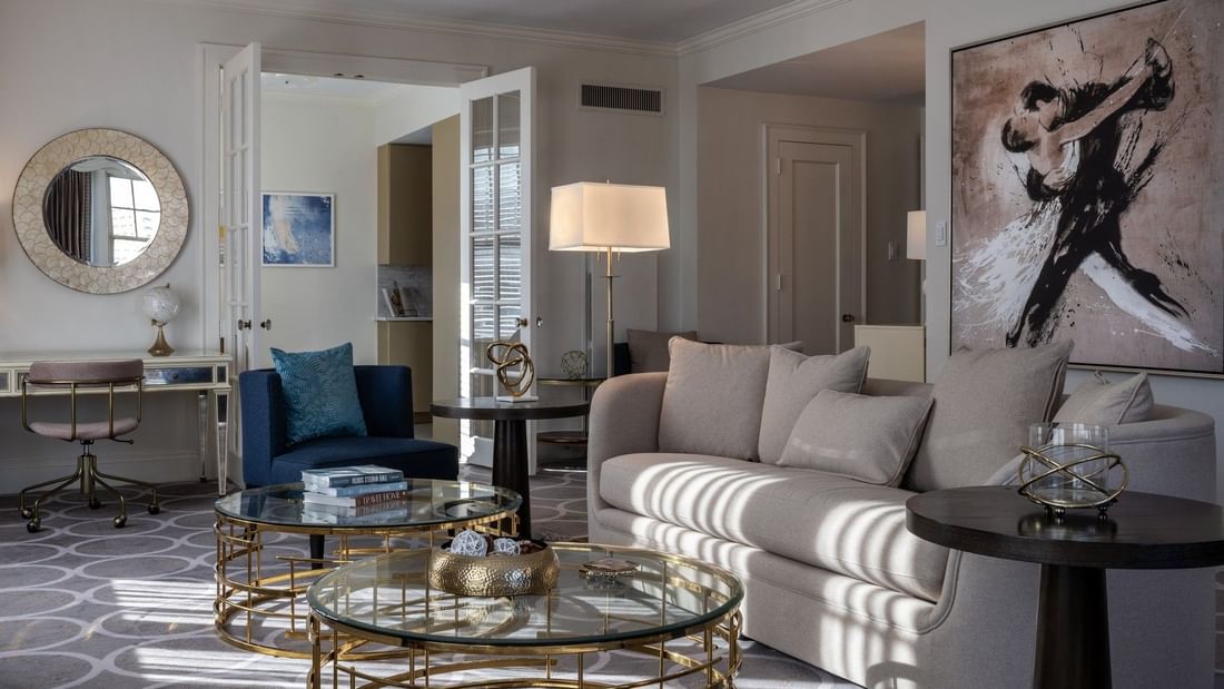 Presidential Suite with Plush beige sofa by tiered gold tables under a white lamp at Warwick Melrose Dallas