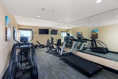 Fitness Center with exercise equipment & mirrors at Boothill Inn & Suites