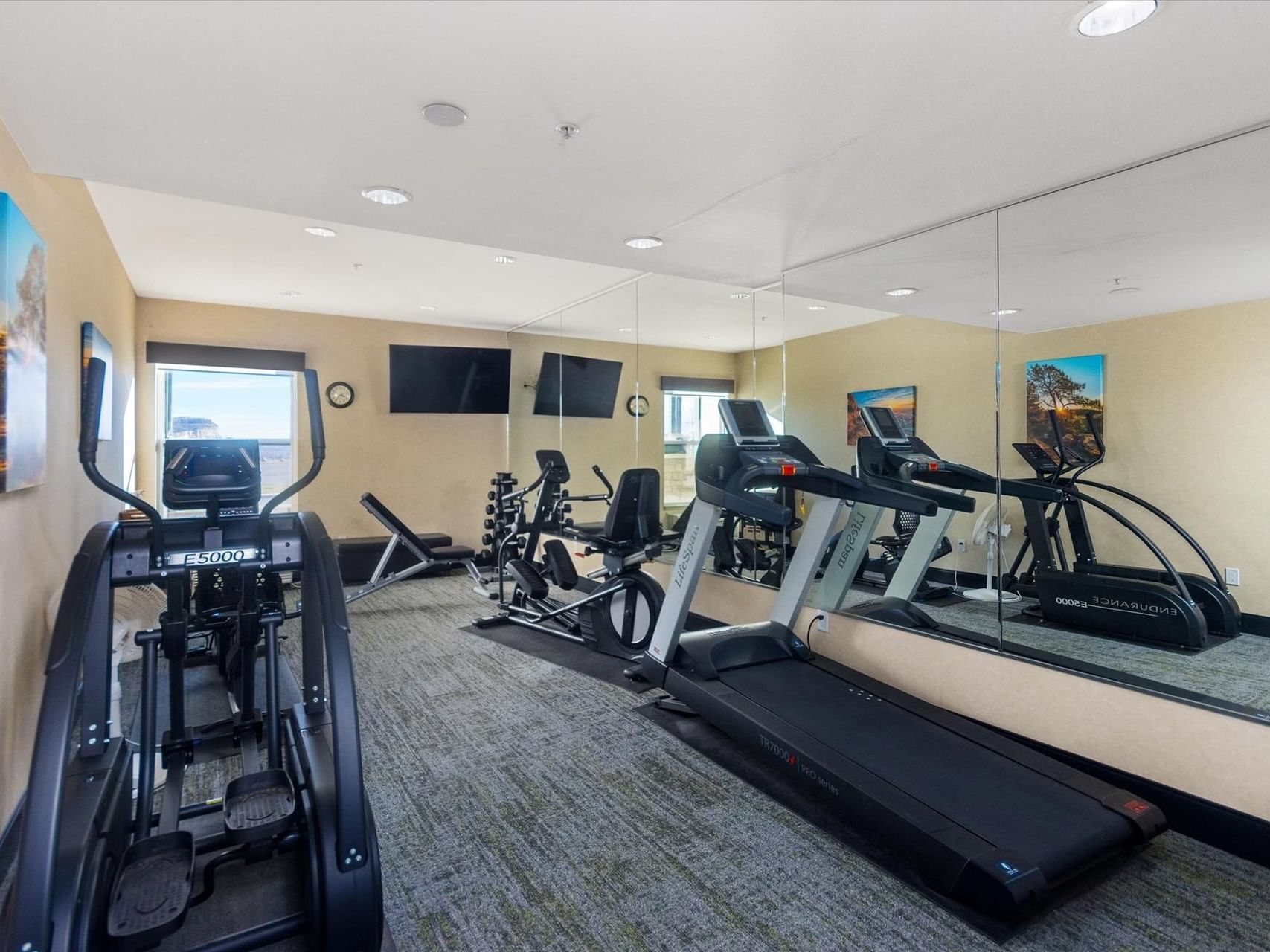 Fitness Center with exercise equipment & mirrors at Boothill Inn & Suites
