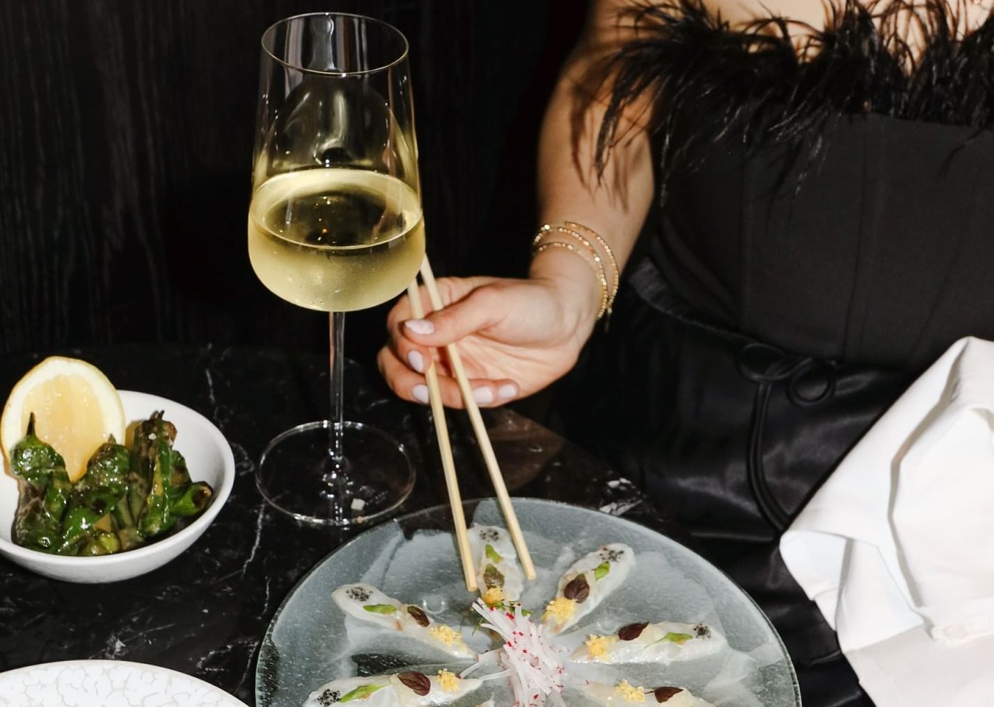 Lady enjoying seafood dish and wine served in a restaurant at The Londoner