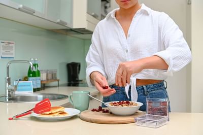 Woman making pancakes & a dessert at Nesuto Hotels