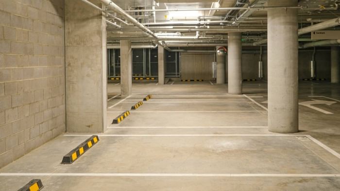Underground parking garage with marked spaces and concrete pillars.