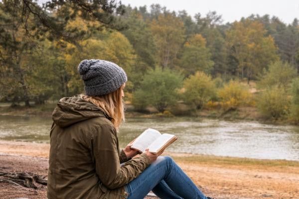 Lady reading War Of The Worlds book by HG Wells at Horsell Common in Woking