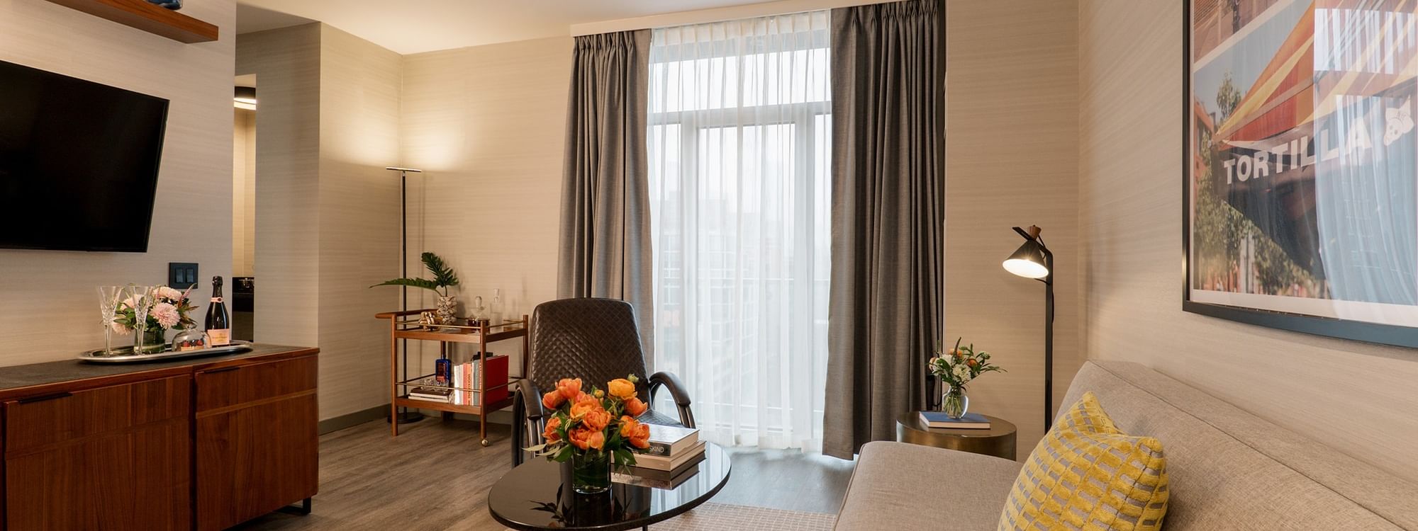 Gansevoort Suite living area with couch, table, and chair at Gansevoort Meatpacking NYC in New York.