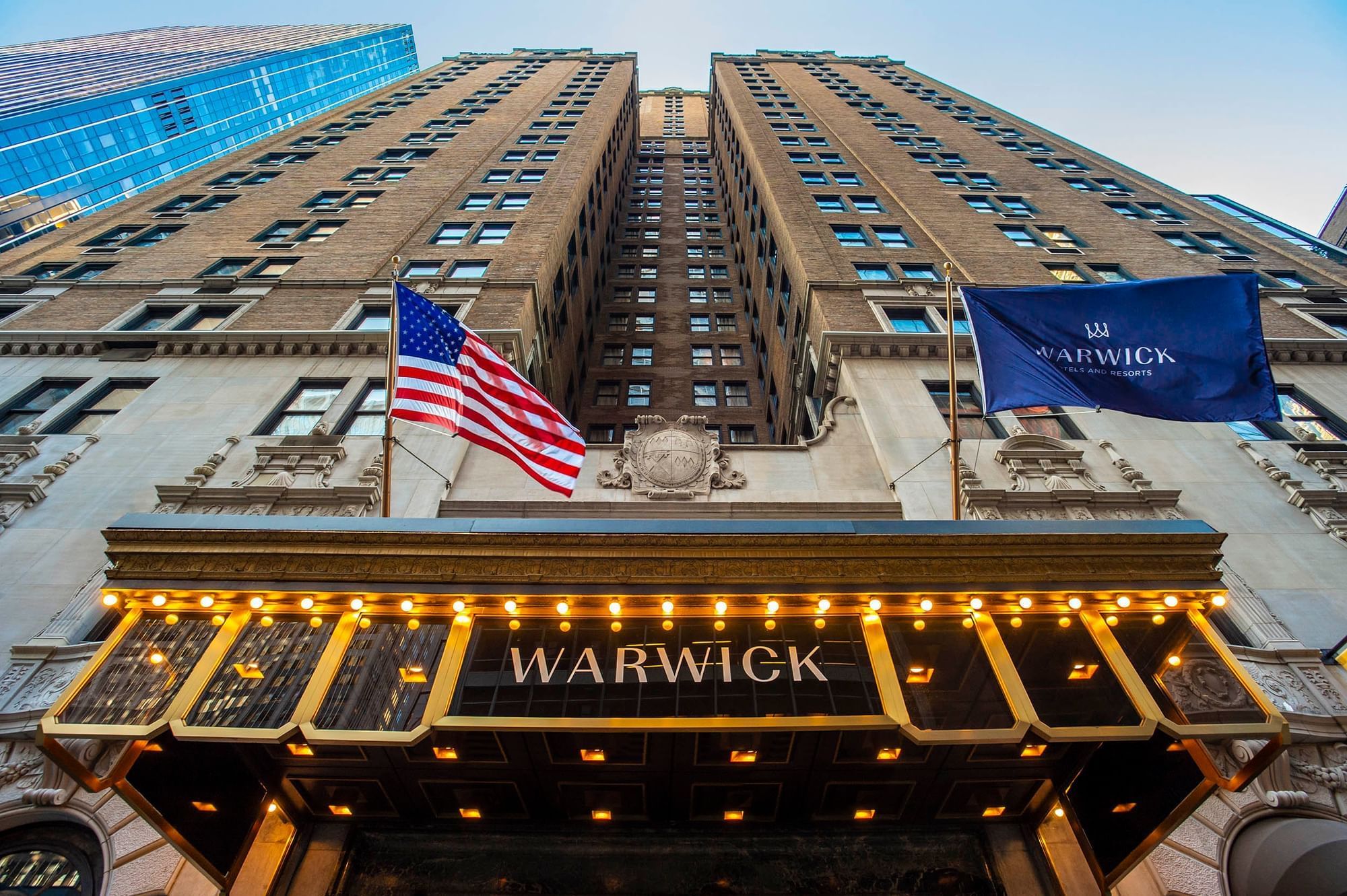 Low-angle view of Warwick New York with an American flag and marquee lights