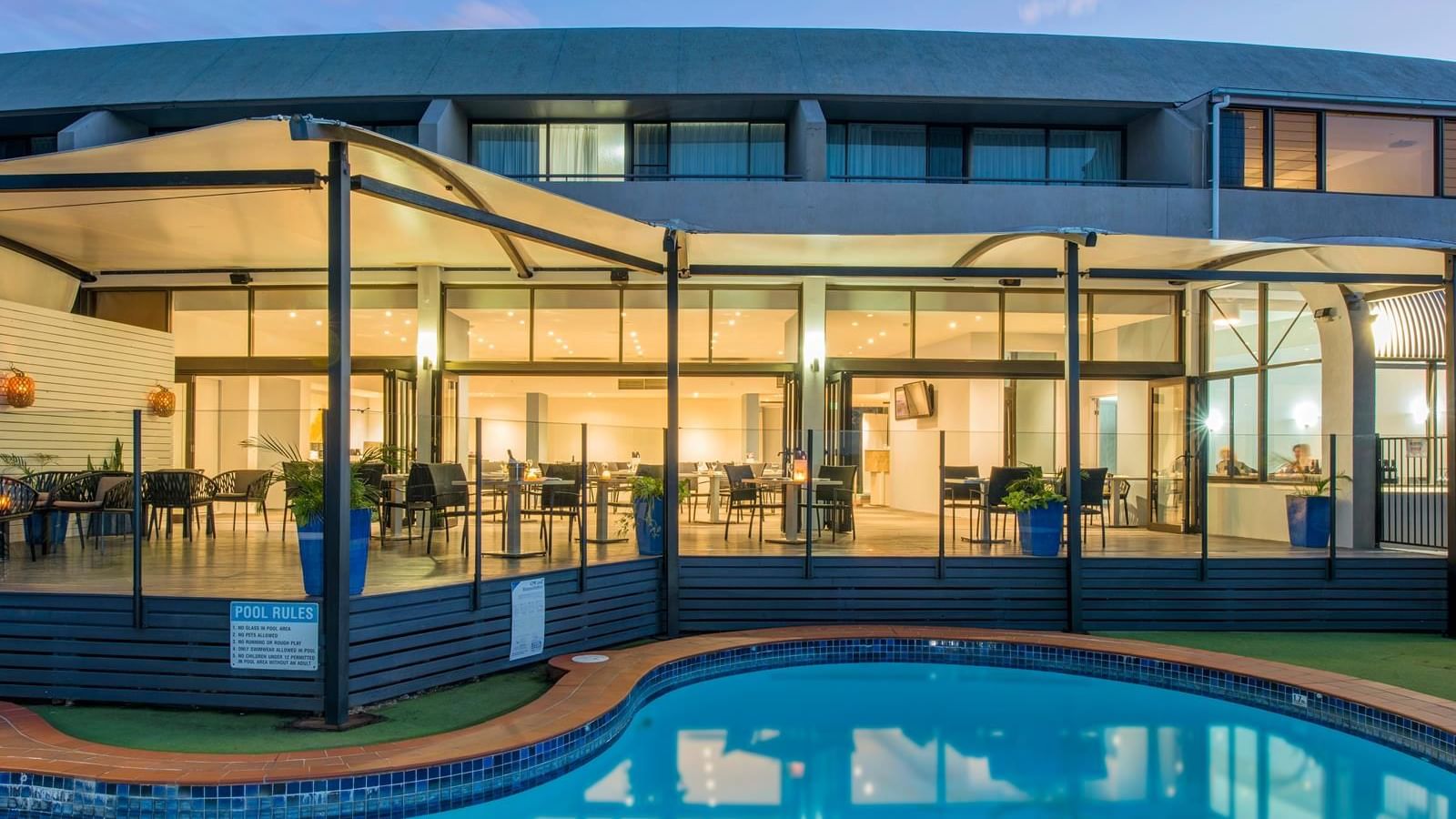 Outdoor pool area beside the dining area with a warm lighting in the evening at Mercure Charlestown