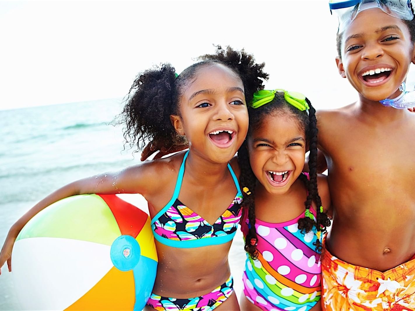 Kids posing for a picture with a beach ball and sea backdrop at Accra Beach Hotel & Spa