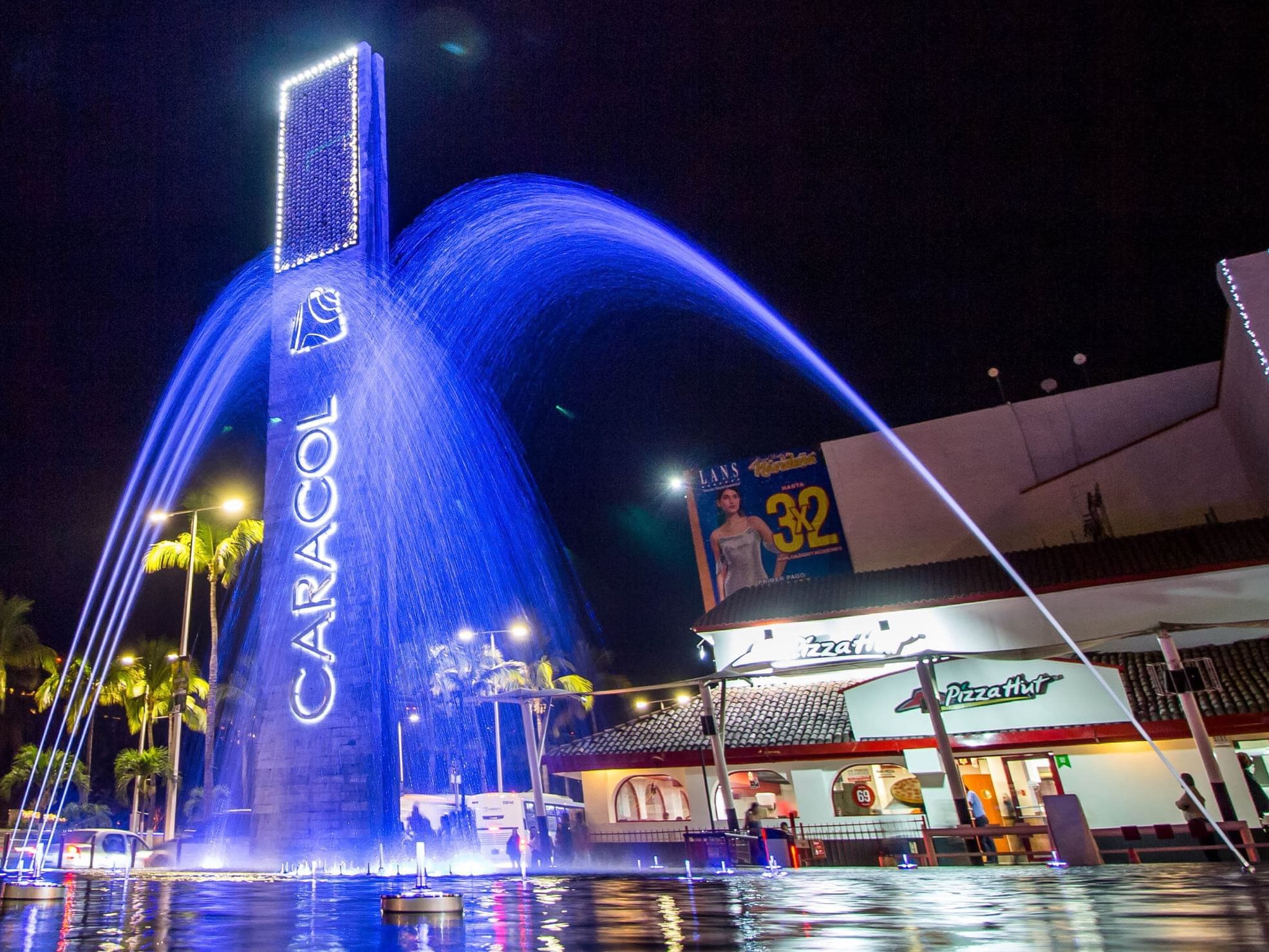 Fountain illuminated at night in Plaza Caracol near Plaza Pelicanos Grand Beach Resort