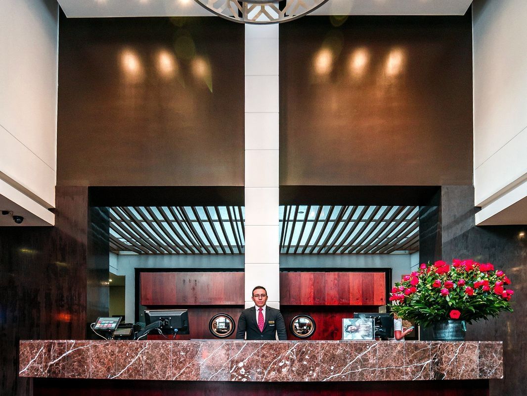 A receptionist by the front desk at Blue Doors Hotels