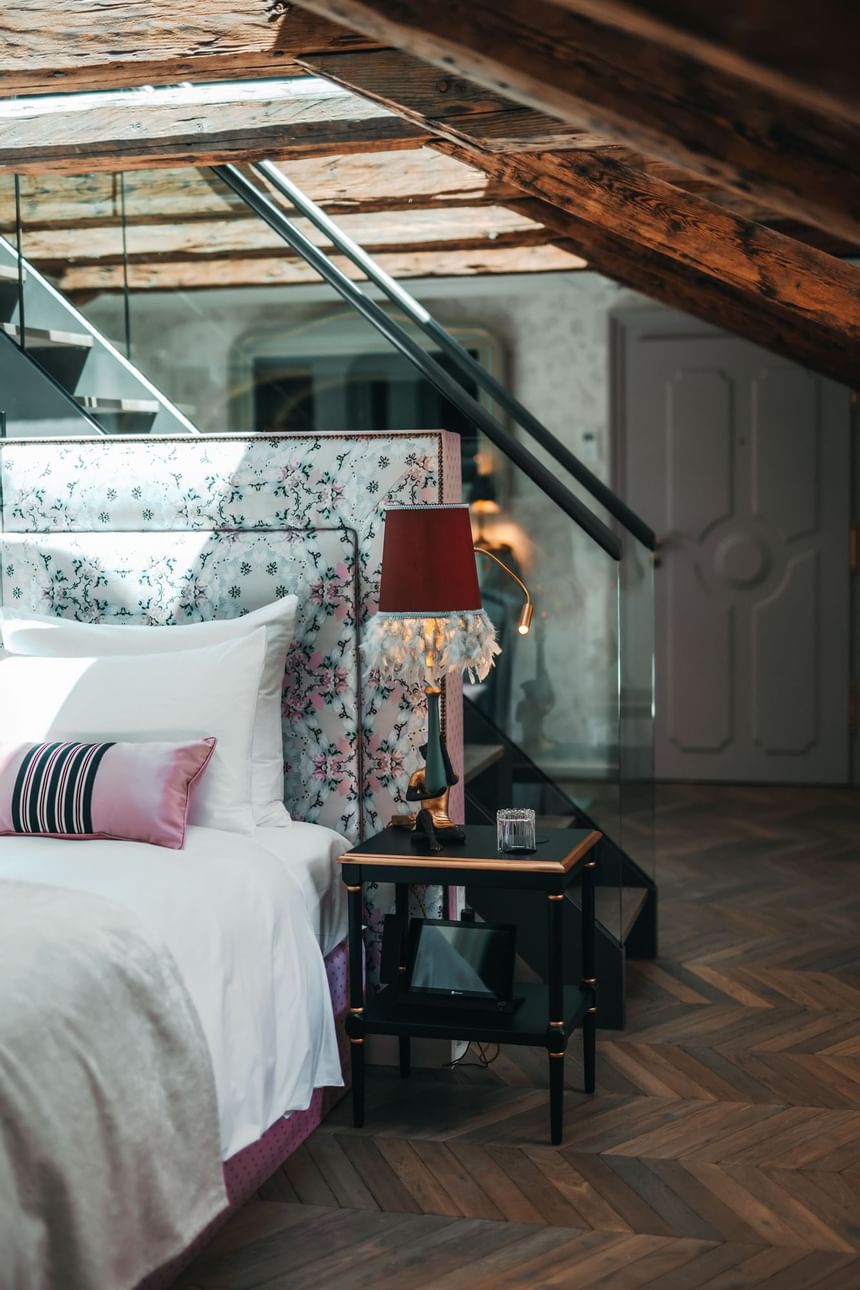 Double bed with patterned headboard on a staircase leading to the second floor in the hotel in Vienna