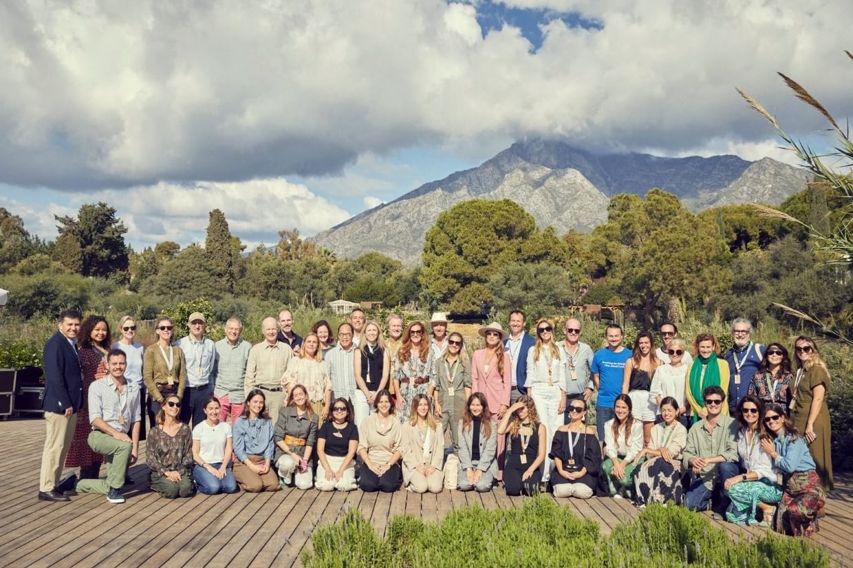 Group of guests gathered on a wooden deck near Marbella Club with La Concha mountain in the background under cloudy skies