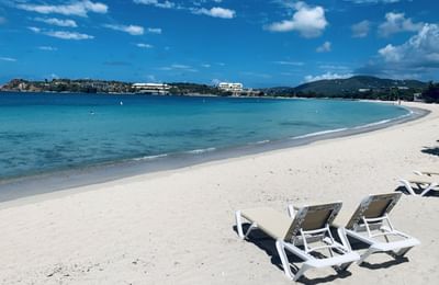 Lounge chairs on Emerald Beach Resort, peaceful beachfront stays at a St. Thomas family resort on Lindbergh Bay, calm water