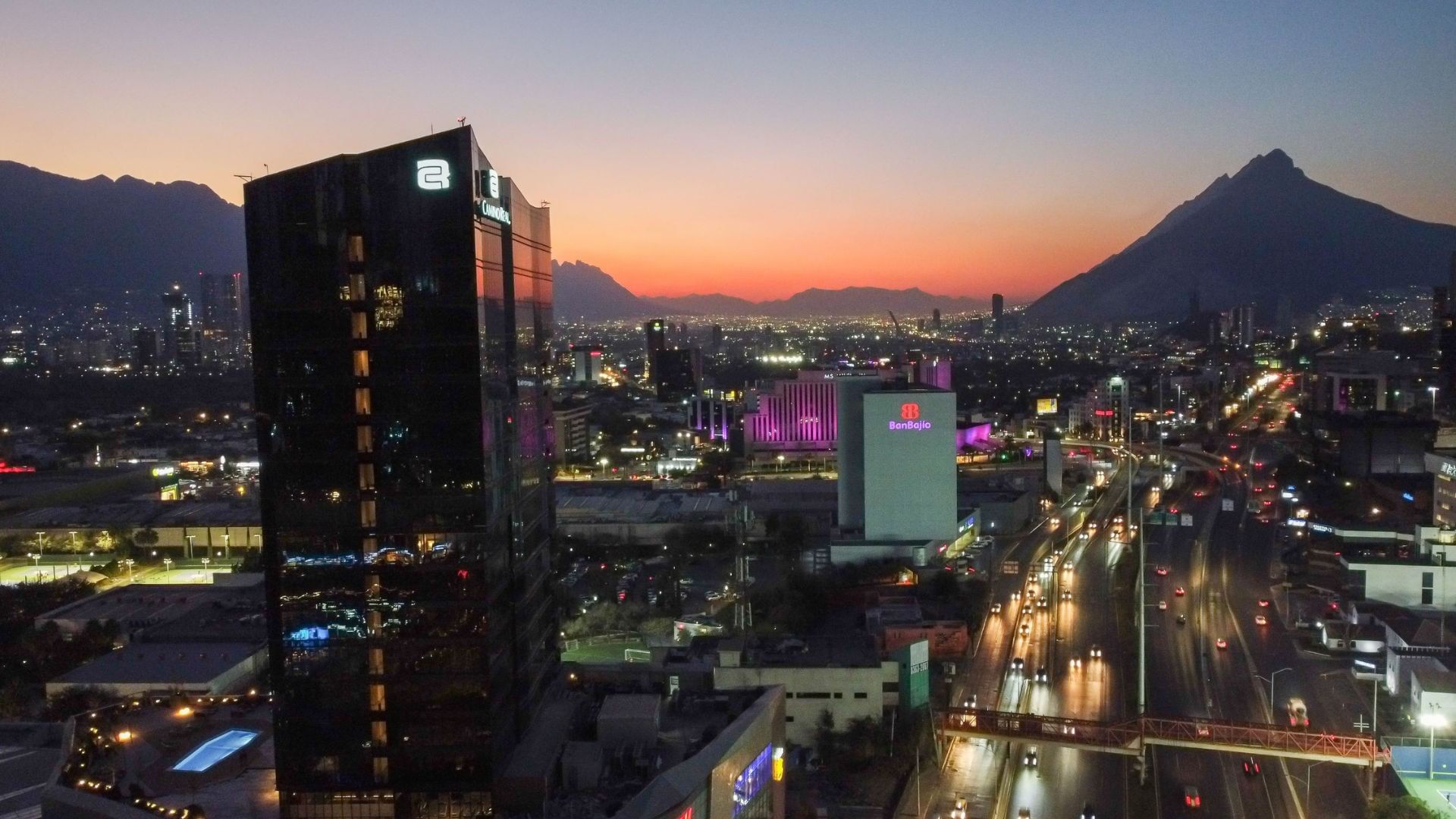 Stunning sunset view of Fashion Drive | Showcente featuring mountains and city lights near Quinta Real Monterrey