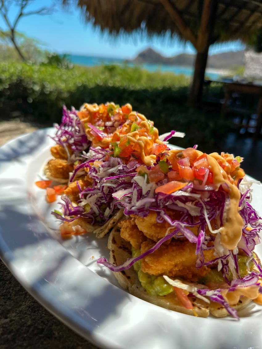 Tacos de pescado con col morada y salsa cremosa servidos en el restaurante La Bastide Beach, en Morgan's Rock Reserve & Ecolodge.