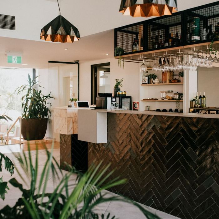 Stylish Mercure Charlestown hotel reception with modern decor and hanging lamps.