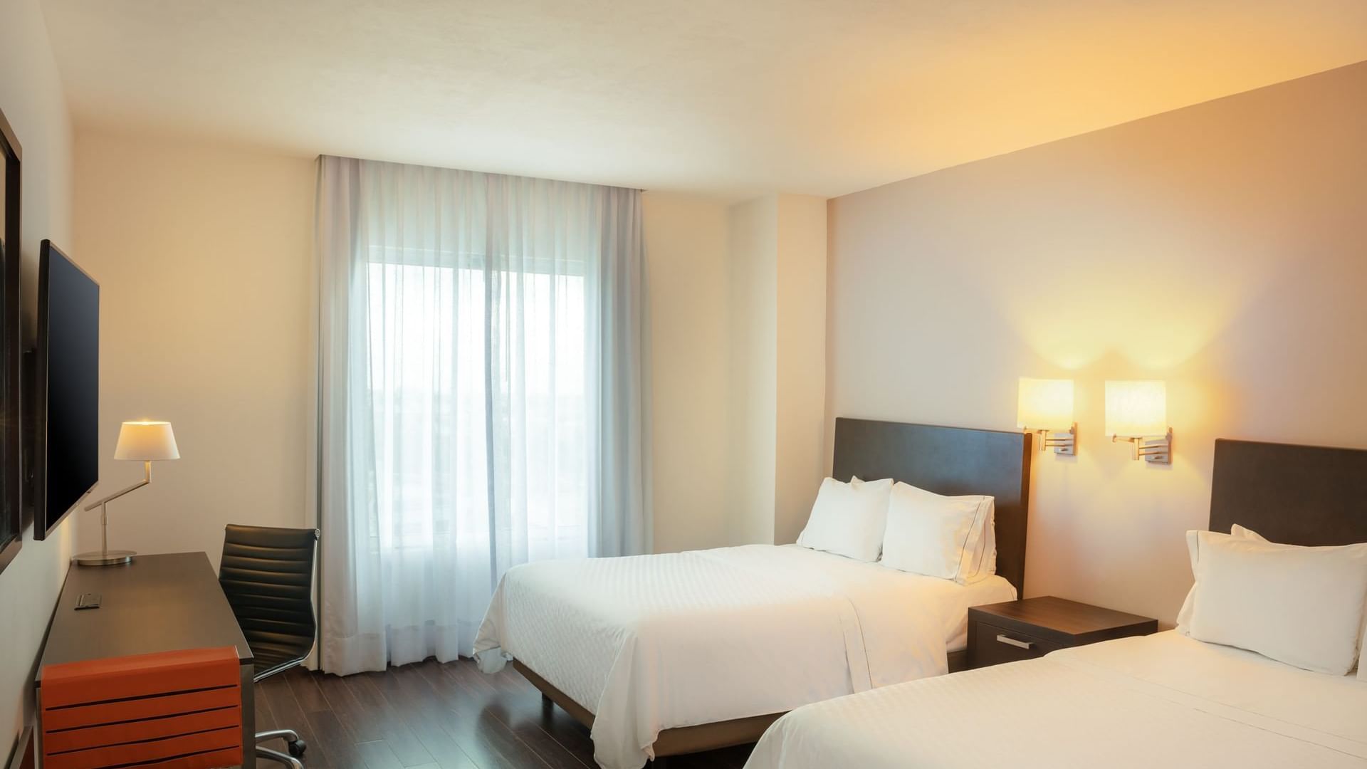 Two beds & furniture in a bedroom at Fiesta Inn Hotels