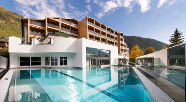 Outdoor pool with hotel exterior at Falkensteiner Hotel and Spa