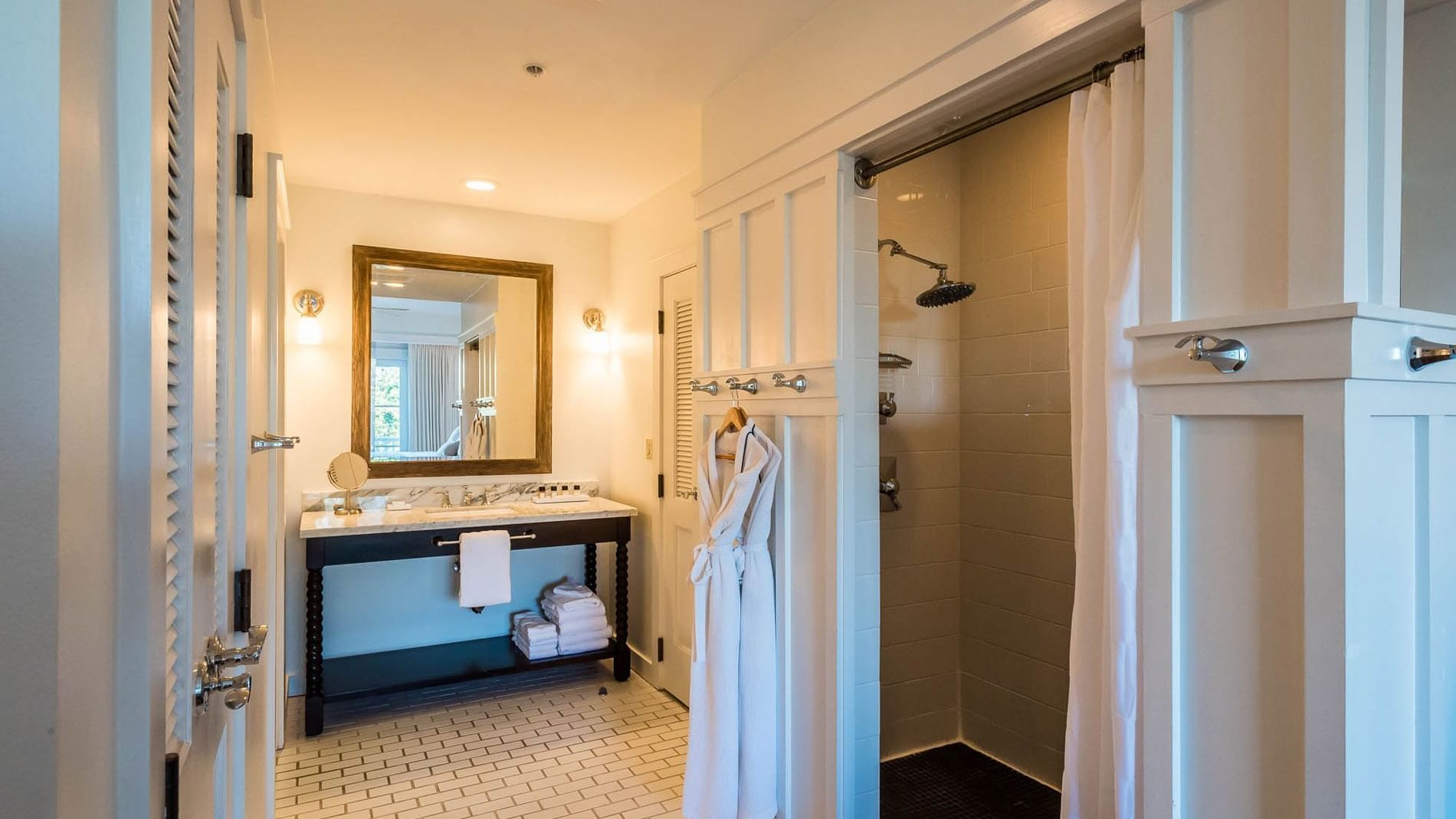 Bathroom area with hanging bathrobes in Resort suite at Watersound Inn