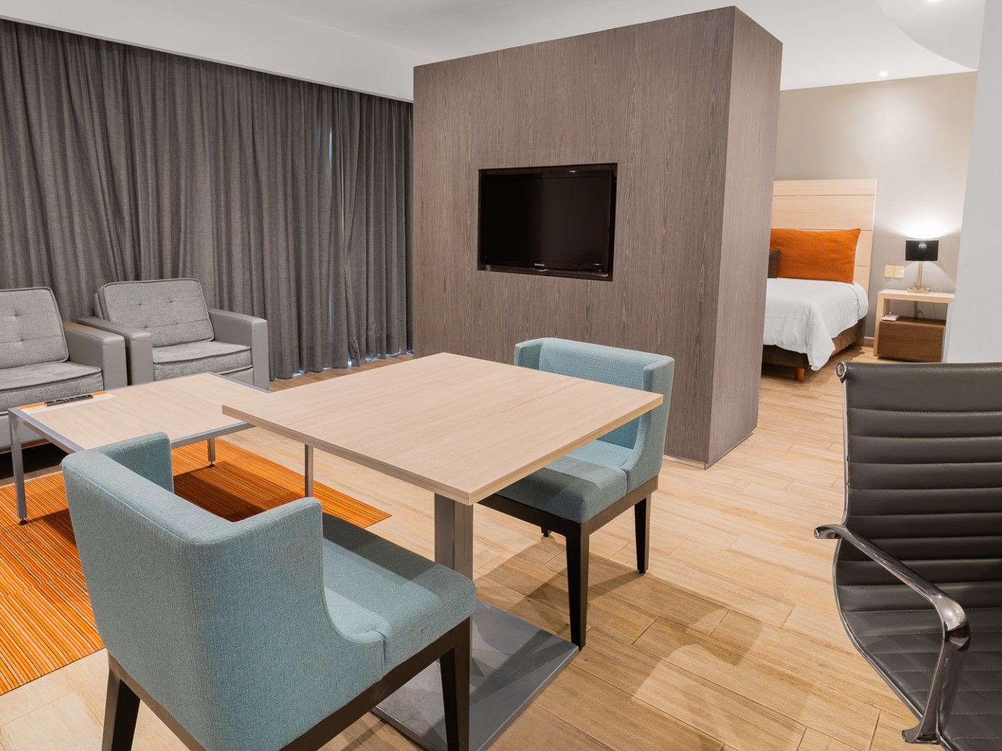 Suite Ejecutiva King en Real Inn Perinorte Tlalnepantla con sofás, mesa, sillas y cama.