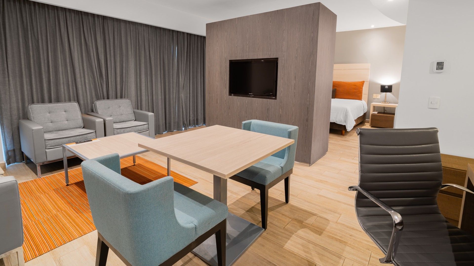 Suite Ejecutiva King en Real Inn Perinorte Tlalnepantla con sofás, mesa, sillas y cama.