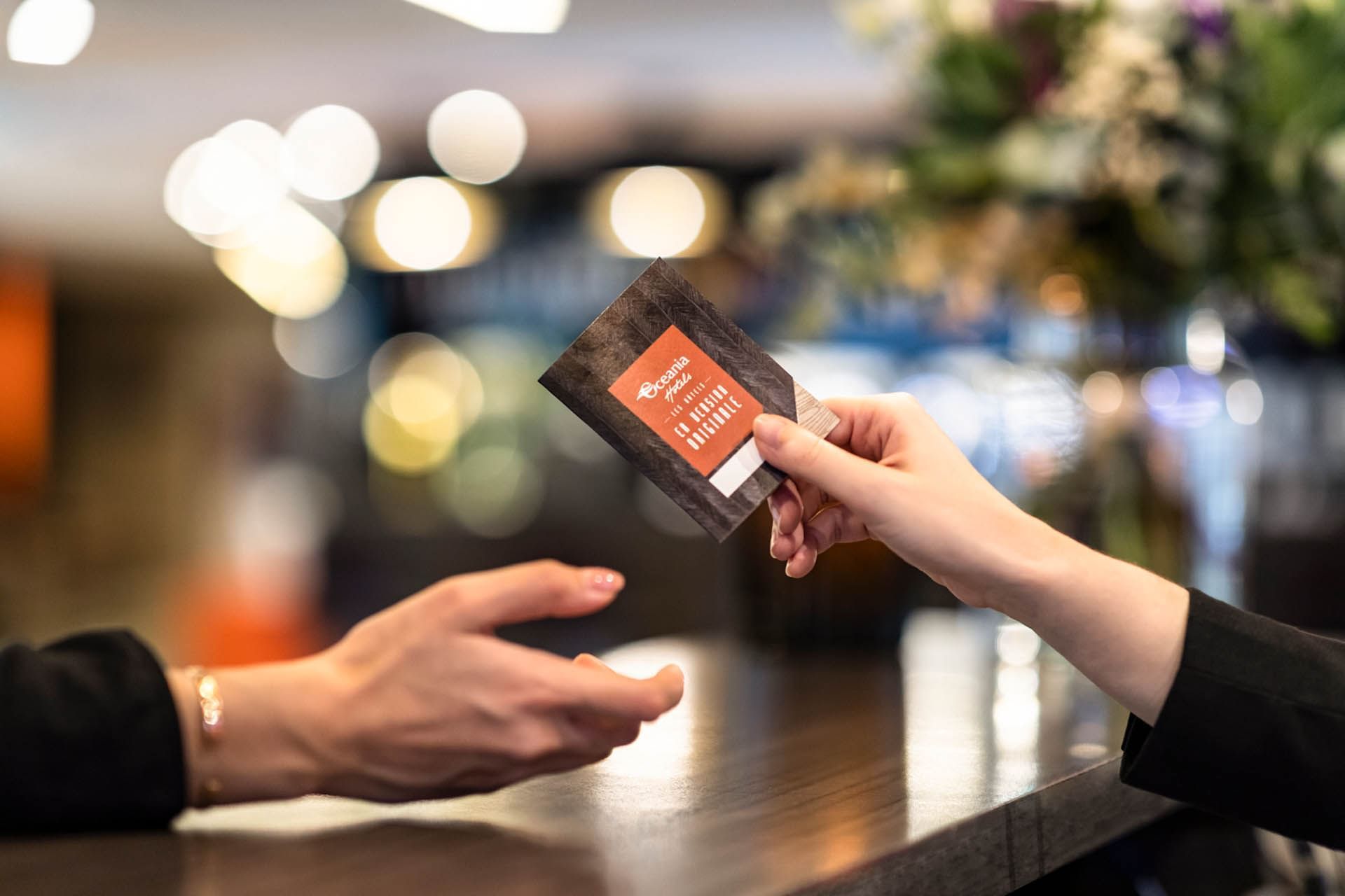 Réceptionniste tenant une carte de chambre à l'Escale Oceania Pornichet