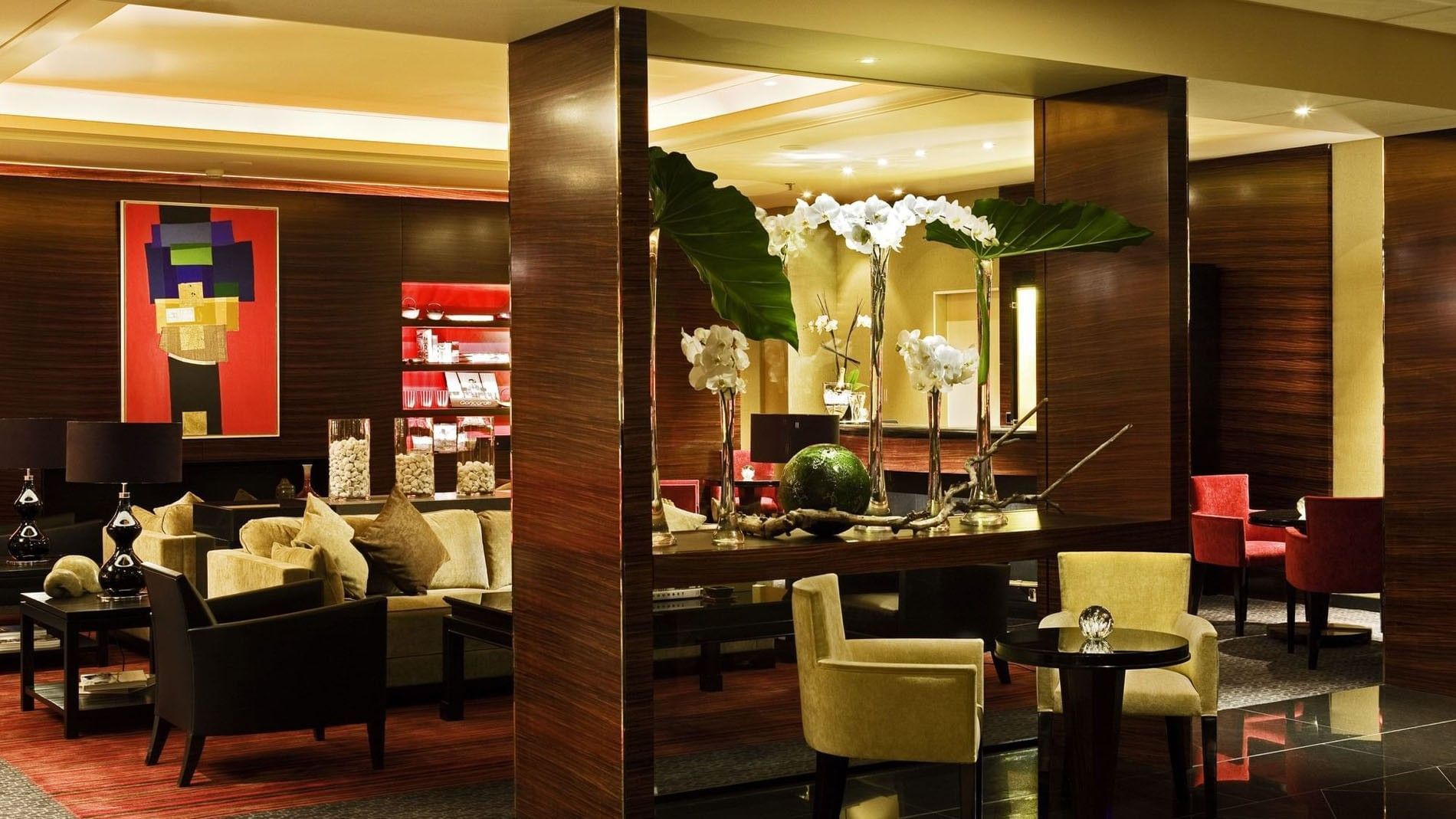Yellow armchairs by a round table under white orchid displays in Bar “Le W” at Warwick Paris Champs Elysées