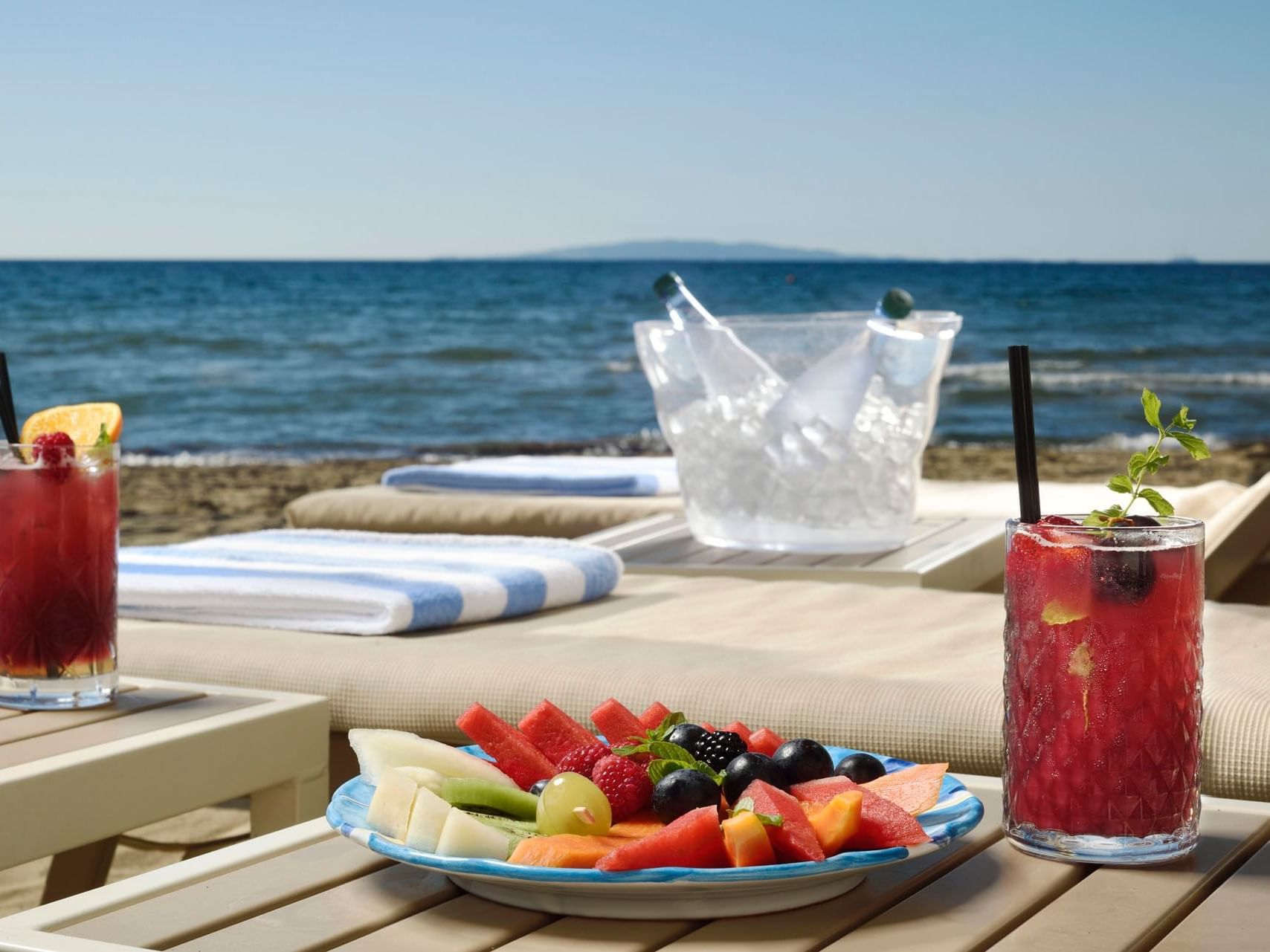 Cocktails & fruit platter served by the sea in Beach Club at Golf Hotel Punta Ala