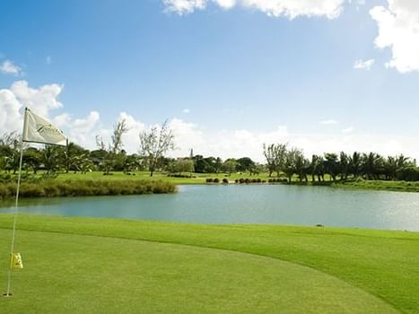 Golf ground featuring a serene pond and lush green grass at Dover Beach Hotel