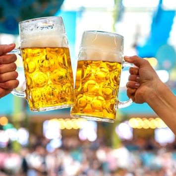 Menschen stoßen mit zwei deutschen Biergläsern in der Nähe des Sylter Hof Hotel in Berlin an